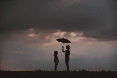 girl holding umbrella on grass field