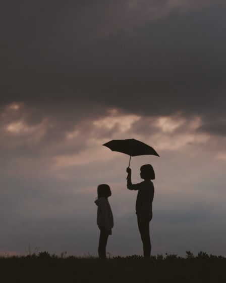 girl holding umbrella on grass field